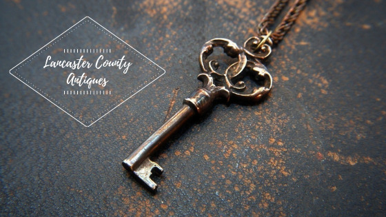 a photo of an antique key with the words Lancaster County Antiques