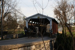 lancaster county covered bridge with a horse and bugging going through the bridge